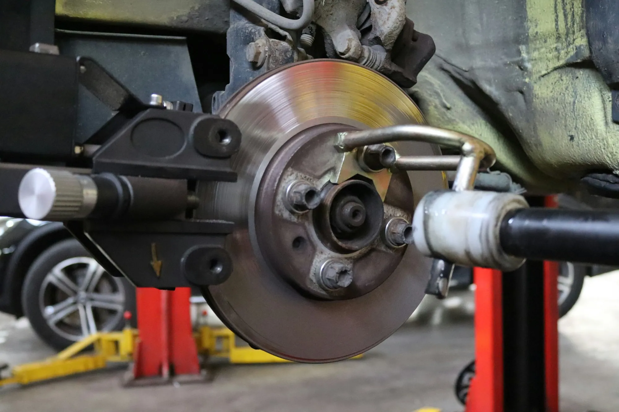 Mechanic fitting a wheel back onto a hub over a new brake rotor